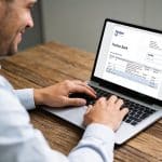 client soulagé devant écran montrant solde bancaire positif