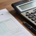Fiche de paie sur bureau avec calculatrice et stylo