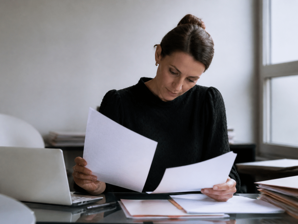 Personne assise a un bureau examinant documents professionnels