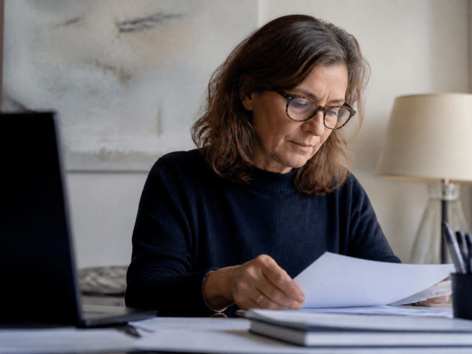 Femme d'age mur assise a un bureau etudiant des documents