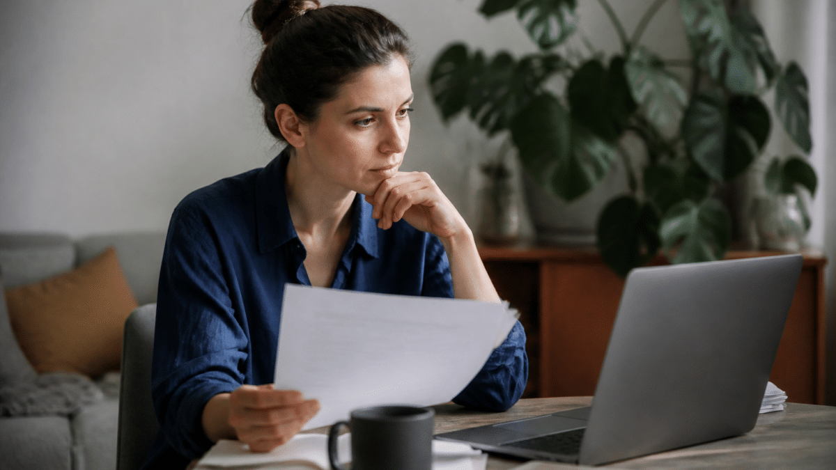 Personne assise face ordinateur consultant documents carriere sociale