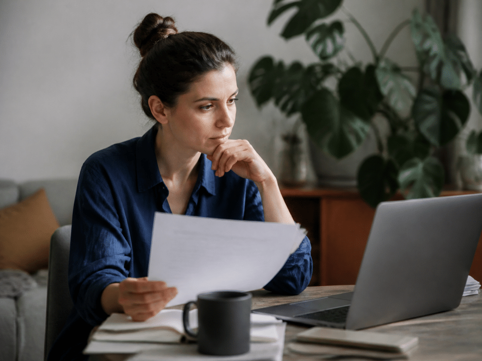 Personne assise face ordinateur consultant documents carriere sociale
