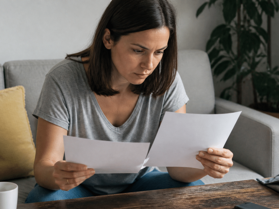 Personne tenant documents financiers comparant deux comptes d'investissement