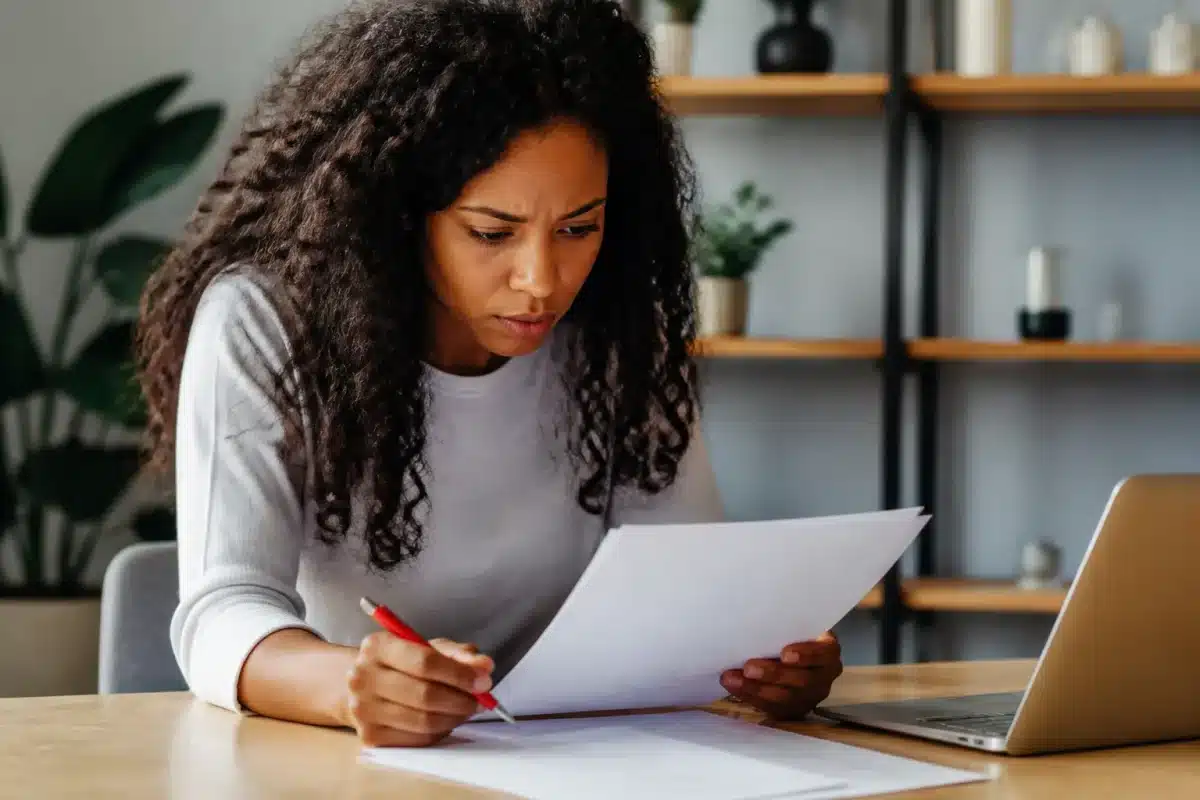 Femme examinant documents officiels avec stylo rouge