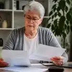 Personne agee assise consultent documents financiers pension retraite