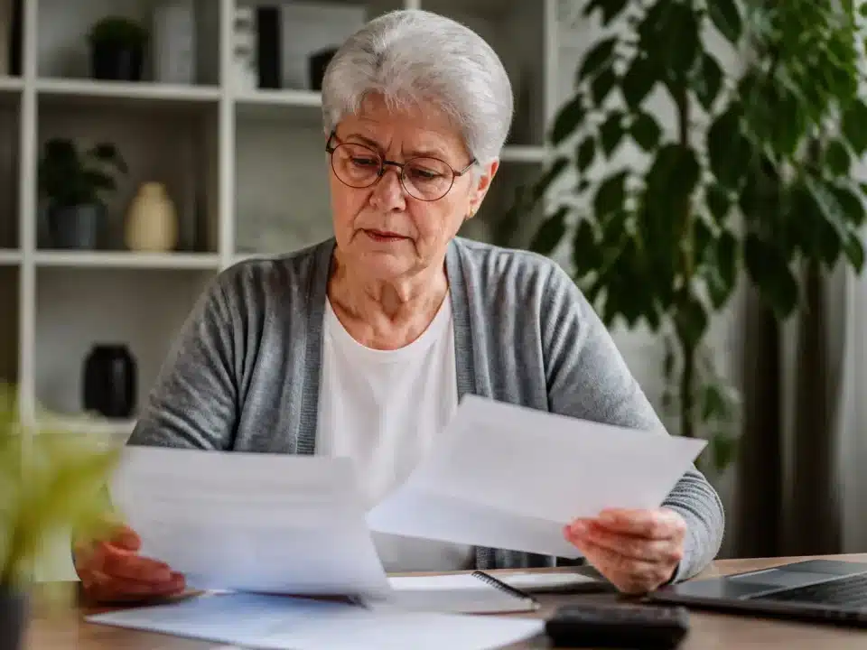 Personne agee assise consultent documents financiers pension retraite