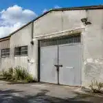 Batiment industriel d'abattoir fermé avec portes cadenassées et murs gris délabres