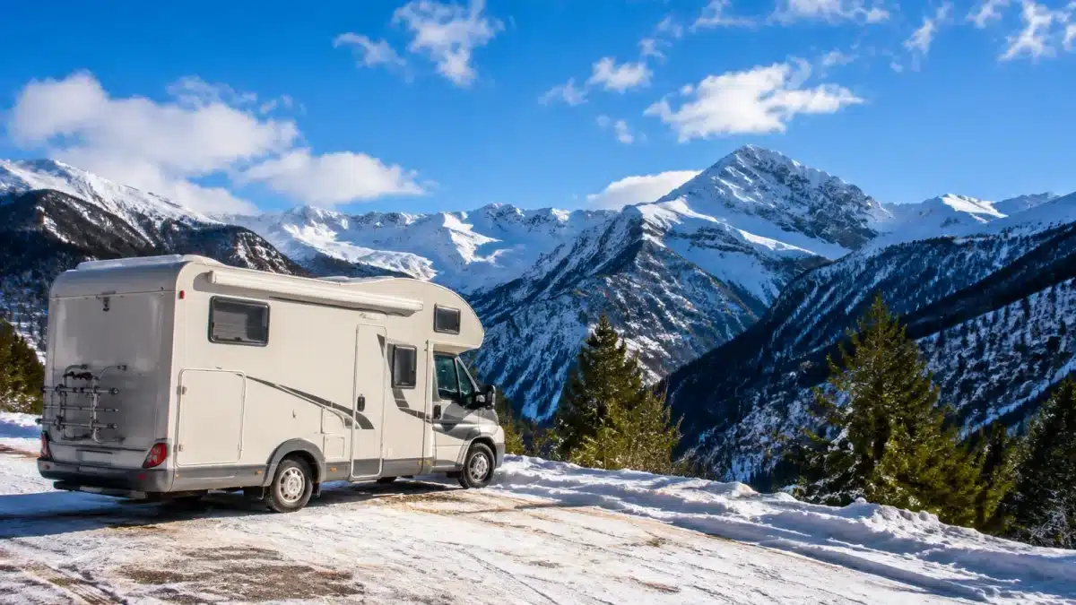Camping-car stationne face aux montagnes enneigées espagnoles l'hiver