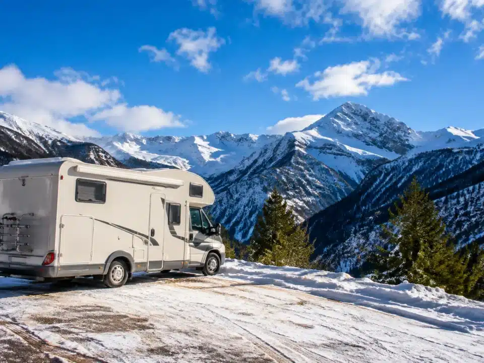 Camping-car stationne face aux montagnes enneigées espagnoles l'hiver