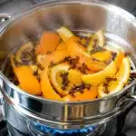 Casserole vapeur contenant clous girofle et zestes orange sur feu