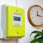 Compteur electrique affichant heures creuses avec horloge murale indiquant apres-midi