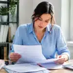 Femme assise a son bureau consultant des documents administratifs