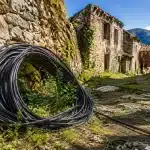 Cable optique enroule au sol devant entree village abandonnee