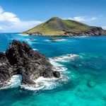 Iles volcaniques noires surgissent de l'ocean turquoise