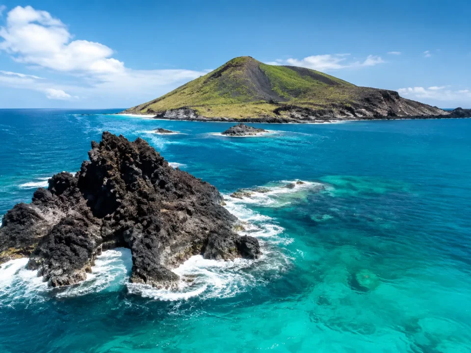 Iles volcaniques noires surgissent de l'ocean turquoise