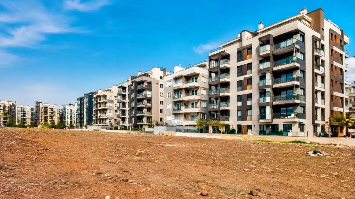 Immeubles collectifs surplombant un terrain vague sans végétation