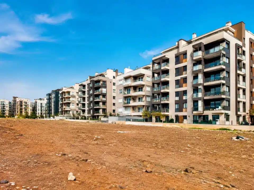 Immeubles collectifs surplombant un terrain vague sans végétation