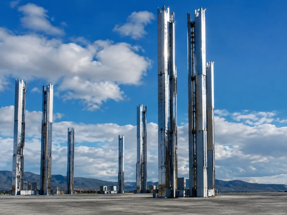 Installations metalliques enormes s'elevent verticalement sur terrain plat gris