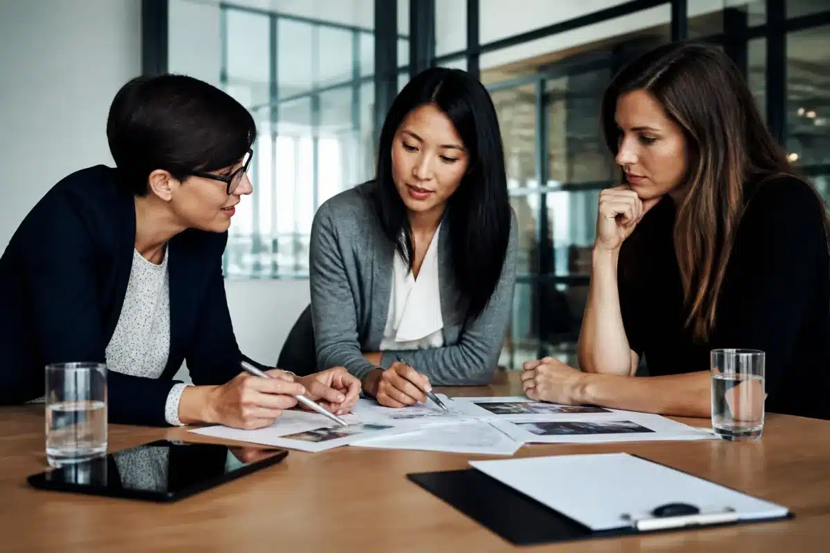 Femmes professionnelles discutant autour table documents