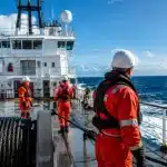 Navire câblier en mer avec équipage sur le pont supérieur