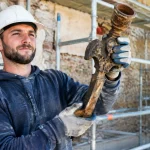 Ouvrier brandissant objet ancien debris chantier renovation batiment