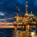 Plateforme acier massive derrick eclairee surplombant ocean sombre