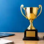 Trophee recompense pose sur bureau professionnel fond bleu