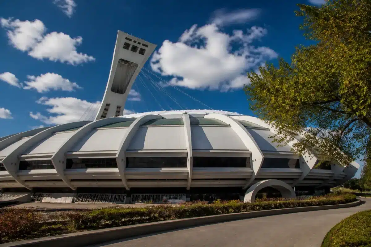 Stade olympique avec dôme blanc et infrastructure massive datée