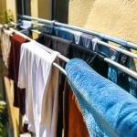 Vetements trempes suspendus sur barres d une structure etroite
