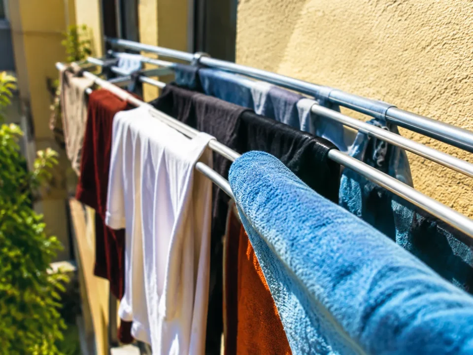 Vetements trempes suspendus sur barres d une structure etroite