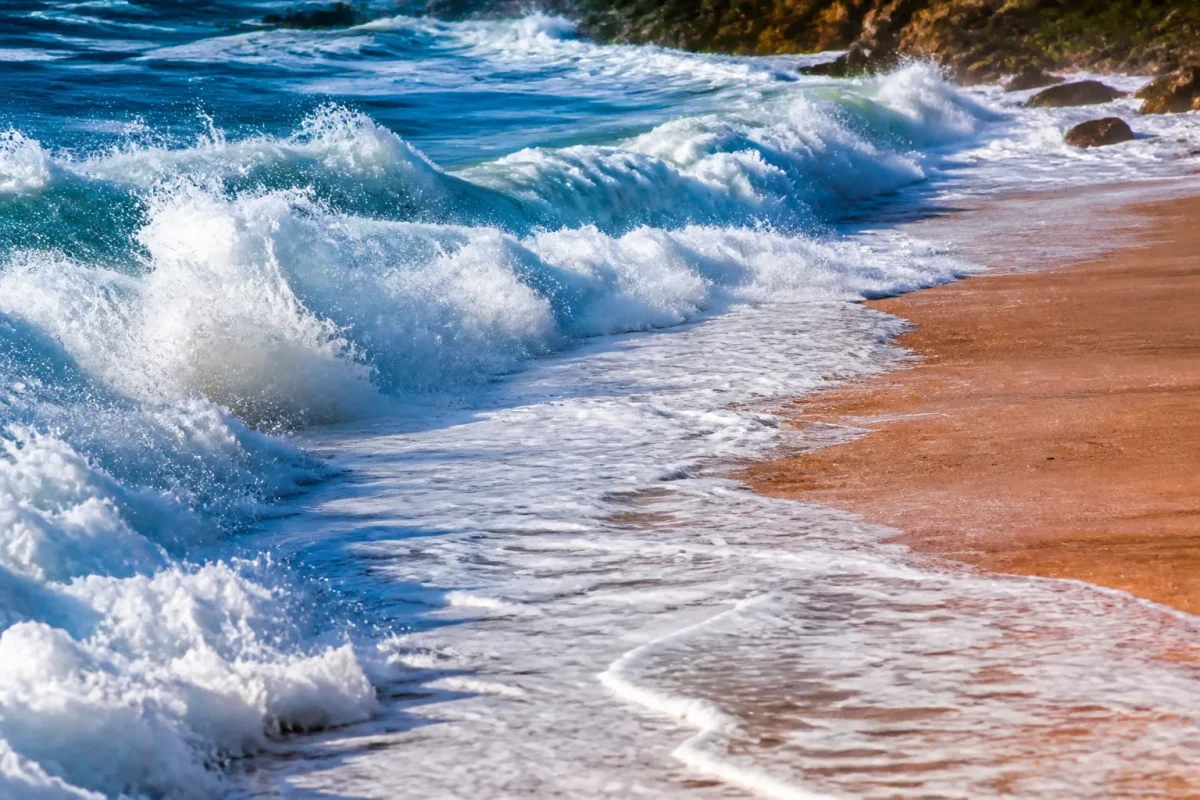 Vagues deferlantes submergeant progressivement cotes sablonneuses